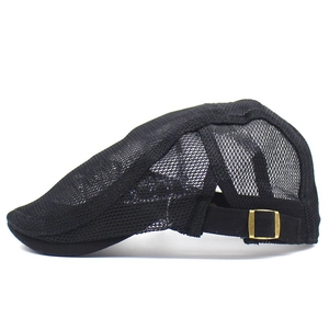 Close-up of breathable black mesh fabric and brass adjustment buckle on the flat cap