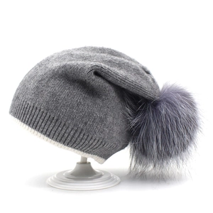 Bonnet en tricot gris pour femme avec grand pompon en fourrure et rayure blanche