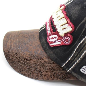 Détail d'une casquette rétro avec visière en cuir craquelé et coutures contrastées