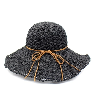 Detail of hand-woven black raffia sun hat with breathable crochet texture and brown leather cord