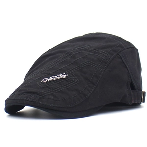 Détail du logo en métal sports sur béret en coton noir avec coutures décoratives