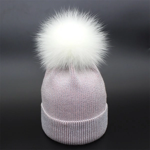 Pink knit beanie for women featuring silver glitter yarn and a white faux fur pompom