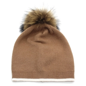 Détail du bonnet en maille camel avec pompon en fourrure et revers à rayures blanches