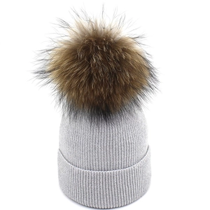 Women's warm grey knitted beanie hat with a large fluffy brown faux fur pom pom top