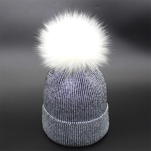 Women's dark blue ribbed knit beanie with metallic thread and white faux fur pom-pom