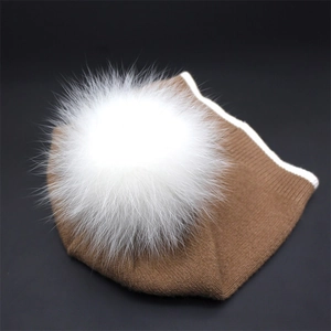 Detail of caramel knit beanie with premium white faux fur pom-pom and striped edge