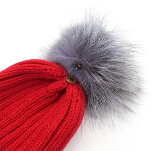 Winter red knitted beanie with detachable grey faux fur pom-pom and ribbed texture