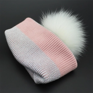 Pink and silver sparkling knit beanie for women with a large white fluffy fur pompom