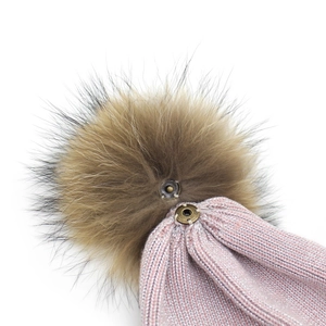 Detail of detachable faux fur pompom with metal snap button on pink knit beanie hat