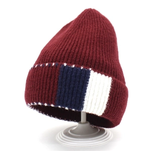 Thick burgundy knit beanie for women featuring a ribbed texture and red-blue side stripe