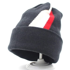 Detailed close-up of dark grey knitted beanie featuring red and white vertical stripes