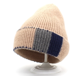 Detailed view of beige wool blend knitted hat with grey and navy blue color block cuffs