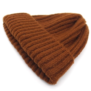 Detailed macro view of dark brown chunky rib knit beanie with thick roll-up cuff for winter