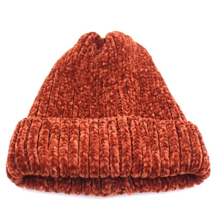 Detail of rust red chenille knit beanie showing thick ribbed texture and folded cuff