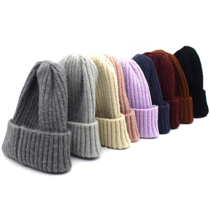 Multiple colors of ribbed knit beanie hats including grey, beige, and pink for winter