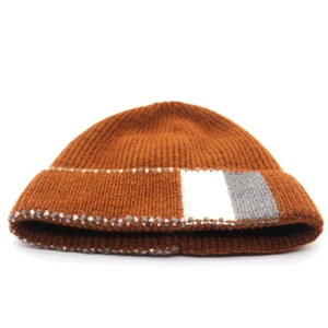 Detail of caramel knit beanie showing vertical striped cuff and fine ribbed wool texture