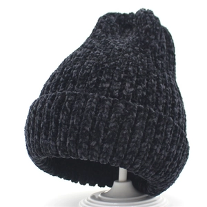 Close-up of black chenille knit hat showing thick textured weave and warm fabric detail