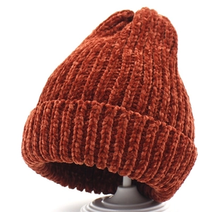 Close-up of thick chenille knit winter beanie in deep rust brown with ribbed texture