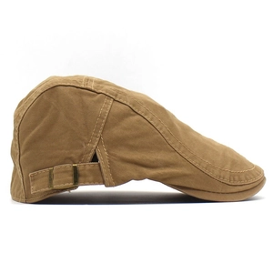 Close-up of adjustable bronze metal buckle and cotton fabric texture on khaki flat cap