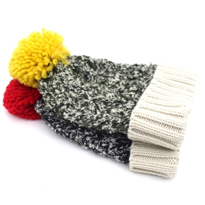 Close-up detail of thickened knit hats with contrasting colorful fluffy pom-poms