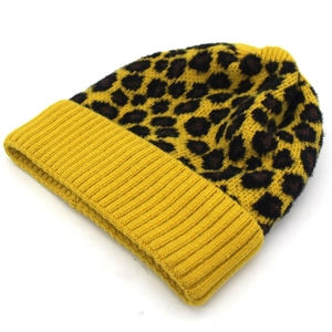 Gedetailleerde weergave van gele beanie met luipaardprint en dikke ribgebreide textuur
