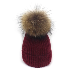 Detailaufnahme der burgunderroten Strickmütze mit großem flauschigem Echtfell-Bommel