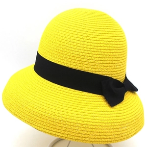 Dettaglio del cappello da sole in paglia gialla con fiocco nero e trama intrecciata
