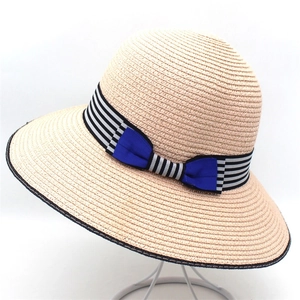 Women's wide brim straw sun hat with striped ribbon and blue bow for summer beach