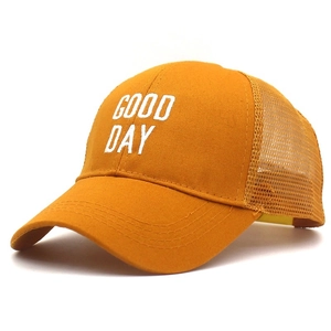 Detail of yellow baseball cap featuring GOOD DAY embroidery and breathable mesh texture