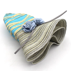 Detailed close-up of sky blue fabric flowers and wavy stripe pattern on women sun hat