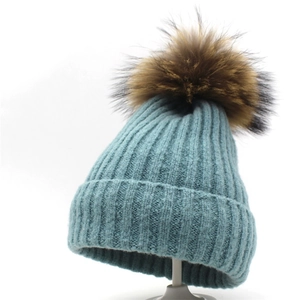 Detailansicht der hellblauen Strickmütze mit echtem Waschbärpelz-Bommel und Rippmuster