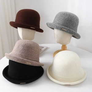 Detalle de sombreros cloché de lana en cinco colores con placas metálicas doradas