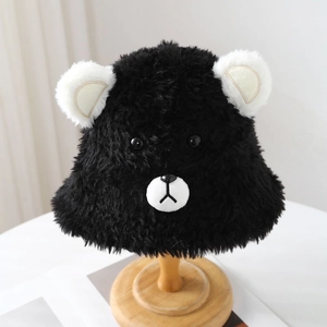 Cute black teddy bear plush bucket hat with white ears on a wooden stand