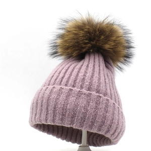 Detailaufnahme der lila Strickmütze mit echtem Waschbär-Pelzbommel für den Winter