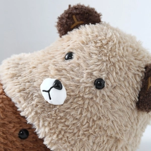Close-up of the soft plush teddy bear hat texture and cute embroidered facial details