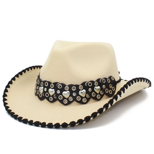 Détail du chapeau fedora beige avec bande en cuir à cœurs noirs et rivets argentés