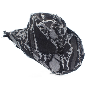 Detail of distressed dark denim cowboy hat with vintage frayed edge and washed texture