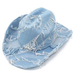 Detail of light blue denim cowboy hat featuring distressed frayed edges and tassels