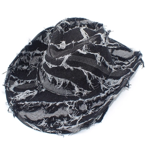 Detail of distressed black denim cowboy hat with torn edges and punk style frayed texture