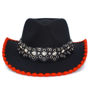 Détail d'un chapeau de cowboy avec bordure rouge et bande en cuir à rivets cœur