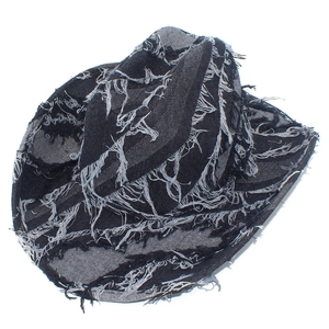 Detail view of frayed denim edges and distressed fringe on a dark navy cowboy jazz hat