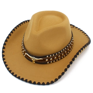 Detail of western cowboy hat with black stitched edges and bull head metal ornament