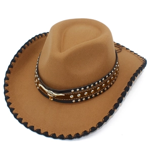 Close-up of brown western cowboy hat with silver studs and a metallic bull head buckle