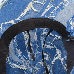 Detail view of denim cowboy hat interior with frayed edges and adjustable sweatband