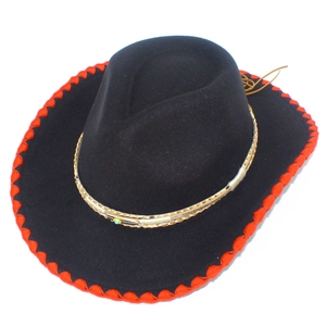Détail du chapeau de cowboy noir avec bordure rouge et perle turquoise décorée