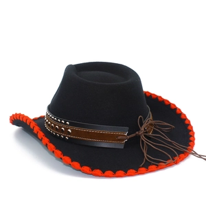 Detail of black cowboy hat featuring red stitched edges and studded leather band with tassels