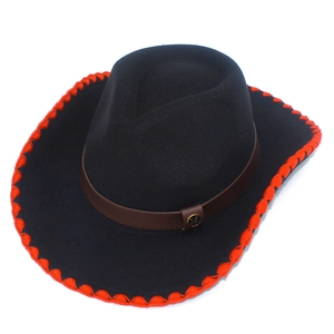Détail d'un chapeau de cowboy noir avec bordure rouge et bande en cuir avec logo M
