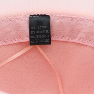 Vue détaillée de l'intérieur du chapeau en feutre rose montrant l'étiquette en coton mélangé