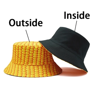Detail of reversible bucket hat with yellow corn grain print and black canvas side