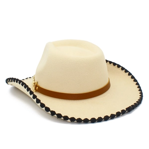 Detail of cream western cowboy hat featuring black wavy stitched edge and leather belt